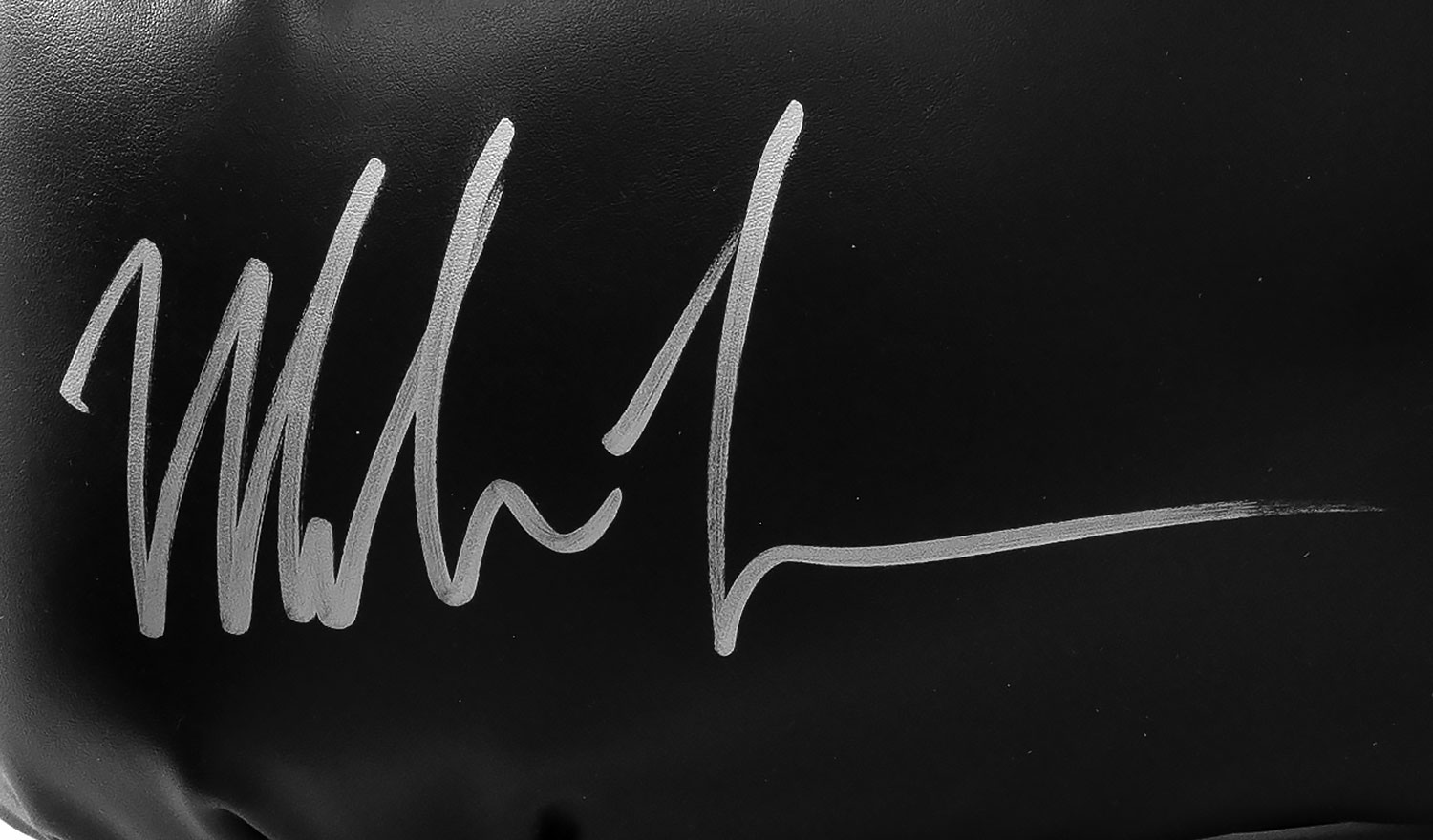 Mike Tyson autograph on black boxing glove in silver ink.